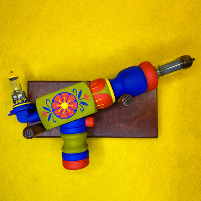 Colorful wooden toy gun with floral design on a yellow background