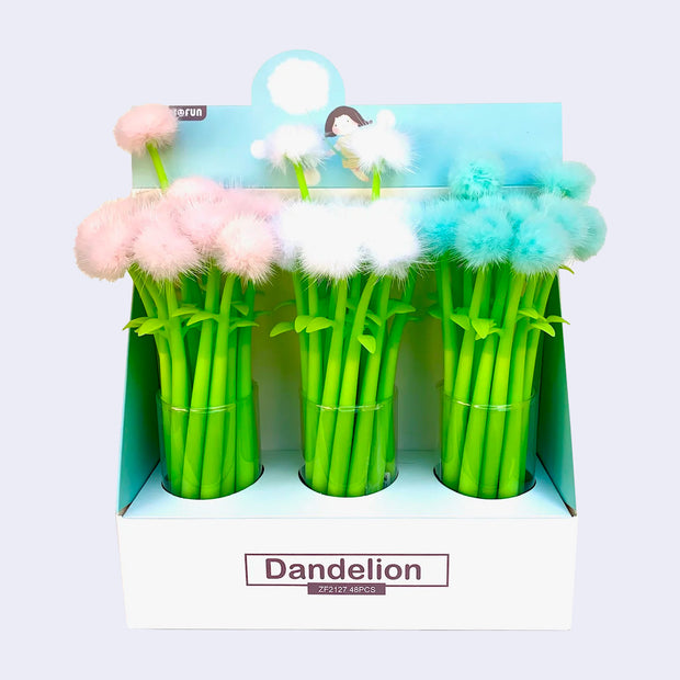 Pen display filled with several green bodied pens with fluffy dandelion like tops. Dandelions are either pink, blue or white.