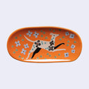Decorative plate with a dog design on an orange background