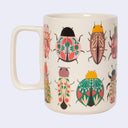White mug with illustrations of patterned beetle bugs.