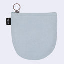 A light blue textured fabric pouch with a silver metal key ring and a black brand tag on the left side, set against a solid light gray background.