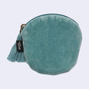 Teal velvet coin purse with a tassel on a light gray background