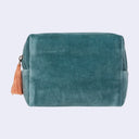 Teal velvet pouch with a tassel on a light gray background