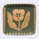 A square green ceramic plate with rounded corners, featuring a raised tan floral motif in the center and a matching tan zigzag border around the edge, shown against a light gray background.