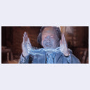 Person with glowing hands in a dimly lit room