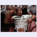 Painting of a muscular figure wearing a shirt with 'Arnold is Numero Uno' text, surrounded by people.