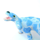 A small ceramic dog figurine with a light blue and white marbled pattern, featuring an open mouth showing pink mouth, white teeth, set against a plain white background.