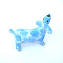 A small ceramic dog figurine with a light blue and white marbled pattern, featuring an open mouth showing pink mouth, white teeth, set against a plain white background.
