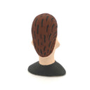 A hand-painted clay figurine of a man's head with brown hair, a beige face, black outlines, and a black shirt, shown against a plain white background.