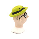 A handcrafted clay figurine of a man's head wearing a bright lime green hat and black-rimmed glasses with white circular lenses, set against a plain white background.