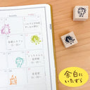 Calendar with cute animal stamps on a wooden surface