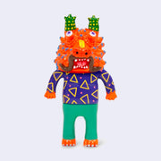 Vinyl figure of a man wearing a bright purple shirt with triangles and green pants. Atop his head is a bright orange dragon head, with many horns atop its head and on its face.