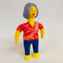 Colorful plastic toy figure with a red shirt and blue pants on a white background