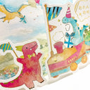 A close-up of a colorful illustrated paper craft or card featuring watercolor-style dinosaurs and a toy train. The scene includes a pink dinosaur in the foreground, a blue dinosaur in a train decorated with a party hat and gift, flags, stars, and Japanese text in the upper right.