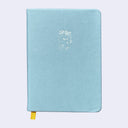 Pastel greyish blue pleather covered sketchbook with a small embossment of a robot carrying a flag that reads "Giant Robot" in the upper center.