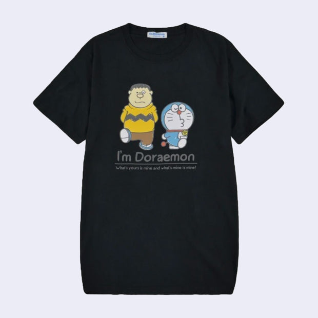 Black t-shirt featuring a graphic of Doraemon and a human wearing a Charlie Brown esque shirt. They both walk and kick up one foot. Below, reads "I'm Doraemon!"