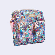 Crossbody purse with 2 front pockets and a long strap. Features pastel pink colored fabric detailing, around the zipper and as the handles/straps. Bag has a small "tokidoki" nameplate on the upper center and is covered completely in a busy colorful pattern featuring tokidoki characters with with galactic and sci fi imagery.