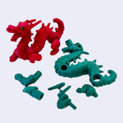 Red and green dragon-shaped erasers- the green one is disassembled into several smaller eraser parts.