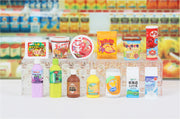Array of 7 drink shaped erasers and 6 food shaped erasers, ones that would be found at convenience stores.