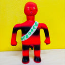 Red and black toy figure with 'REBORED' sash against a yellow background