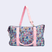 Boxy duffel bag with pastel pink colored fabric detailing, around the zipper and as the handles/straps. Bag has a small "tokidoki" nameplate on the upper center and is covered completely in a busy colorful pattern featuring tokidoki characters with with galactic and sci fi imagery.