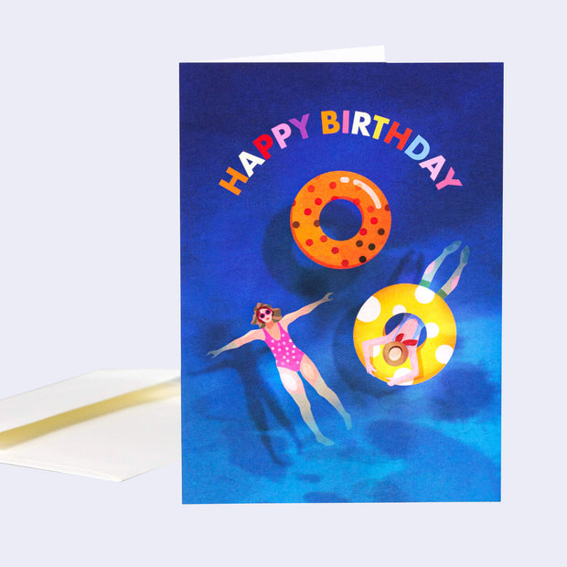 Birthday card with a swimmer and inflatable rings on a blue background