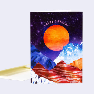 Space-themed birthday card with a red sun and mountains on a purple background