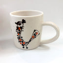 White mug with black and orange design on a white background