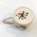 Ceramic mug with floral design on a white background