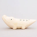 Wooden figurine of a crocodile with a cute, smiling face.