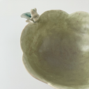 Ceramic vessel, a wide teacup with 2 handles. The bowl of the cup is shaped like a flower and the handles have thorns on them. Atop each handle is a small white bunny character.