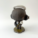 Dark brown ceramic sculpture of a character with a very large head and a small body. It has earring cuffs, a halo, and holds a small white flower.
