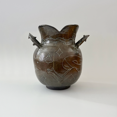 Glossy ceramic vase, with a carved design of a girl holding out her hands with a small bunny planet floating above it. The handles of the vase have thorns.