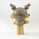 Ceramic statue of a character with closed eyes, a small dress, ear cuffs and their hair up in space-like buns. On their arm is a small caterpillar and on their knee is a bandaid. 