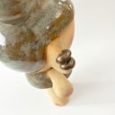 Close-up of a ceramic sculpture of a character with earring cuffs.
