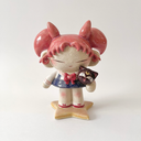 Ceramic figure of a girl with pink, anime-like hair, a sailor outfit and holding a cute black cat head. She stands on a star shaped base.