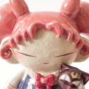 Ceramic figure of a girl with pink, anime-like hair, a sailor outfit and holding a cute black cat head. She stands on a star shaped base.