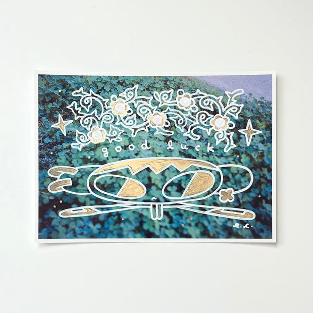 Paint marker illustration atop of a printed photograph of a cartoon character with her legs in a split and text above her that reads "good luck"