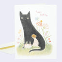 Happy Birthday greeting card with a softly rendered color pencil illustration of a large black cat and a small girl sitting next to it, with a birthday cake. Text reads "happy birthday" in red cursive.
