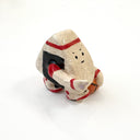 A small hand-painted ceramic figurine of a character resembling an onigiri, wearing red sweatband, and black and red basketball sneakers, holding an orange basketball and pointing, set against a plain white background.