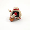 A small hand-painted ceramic figurine of a character resembling an onigiri, wearing red sweatband, and black and red basketball sneakers, holding an orange basketball and pointing, set against a plain white background.