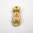Ceramic skateboard sculpture, seen from below with a yellow onigiri graphic and yellow wheels.