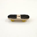 A miniature ceramic skateboard with, black grip tape and a small red and white onigiri graphic in the center, and yellow wheels, shown on a plain white background.