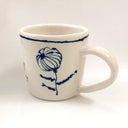 White mug with blue floral design on a white background