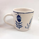 White mug with blue floral design on a white background