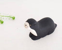 Black otter-shaped wooden figurine on a white background