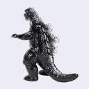 A glossy black Godzilla toy figure with silver claws and feet, standing on a light gray background.