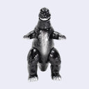 A glossy black Godzilla toy figure with silver claws and feet, standing on a light gray background.