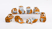 Collection of tiger figurines on a white background