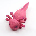 Whittled wooden sculpture of a pink, smiling axolotl.